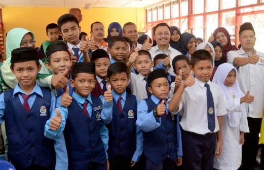 Murid-murid dan guru berkumpul bersama dalam suasana komuniti sekolah